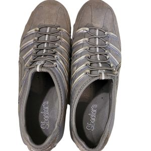 Skechers green outlined with gold ad gray. Slip on.